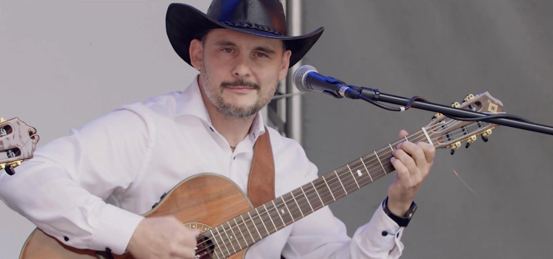 osoba trzymająca gitarę